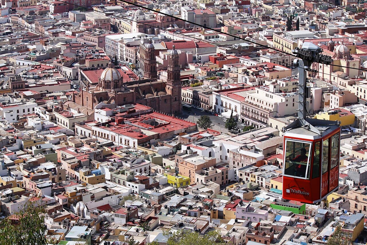Vista panorámica del centro histórico de Zacatecas con edificios, cúpulas y el teleférico.